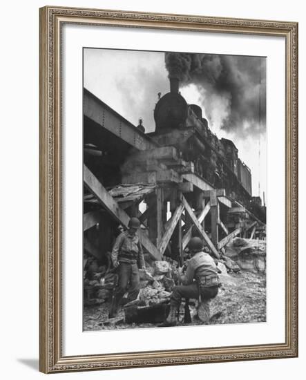 Gi Infantry Guards Keeping Warm by a Fire Next to an Army Engineer Built Railroad Bridge-Ralph Morse-Framed Photographic Print