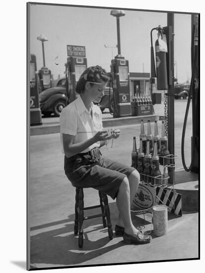 Girl Change Maker Knitting During Slow Moments at the Gilmore Self-Service Gas Station-Allan Grant-Mounted Photographic Print