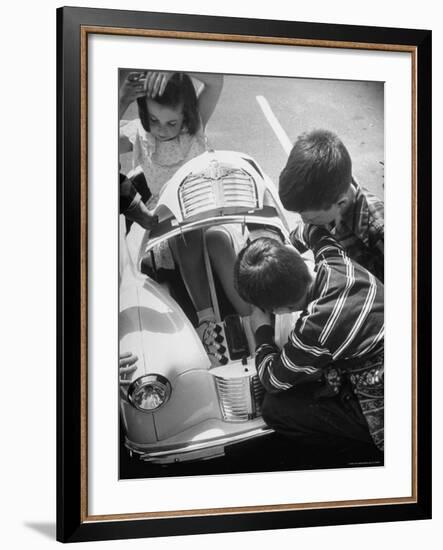 Girl Demurely Adjusting Her Hair While Willing Volunteers Repair Jammed Front Wheels of Her Car-Nina Leen-Framed Photographic Print