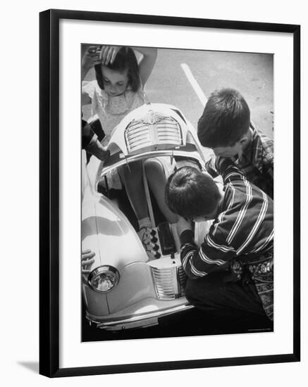 Girl Demurely Adjusting Her Hair While Willing Volunteers Repair Jammed Front Wheels of Her Car-Nina Leen-Framed Photographic Print