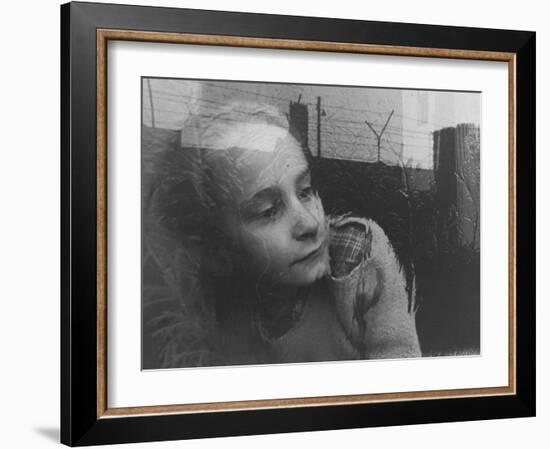 Girl Gazing Pensively Through Pane of Her Apartment Window, Grimly Reflects Image of Berlin Wall-Paul Schutzer-Framed Photographic Print