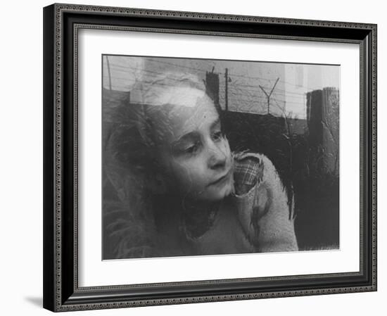 Girl Gazing Pensively Through Pane of Her Apartment Window, Grimly Reflects Image of Berlin Wall-Paul Schutzer-Framed Photographic Print