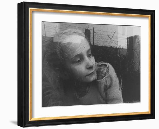 Girl Gazing Pensively Through Pane of Her Apartment Window, Grimly Reflects Image of Berlin Wall-Paul Schutzer-Framed Photographic Print