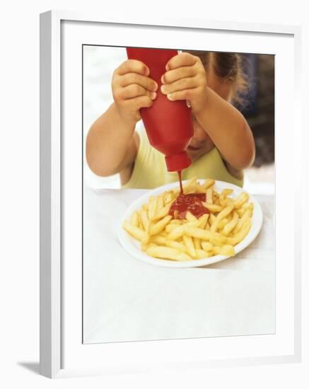 Girl Squeezing Ketchup Over Chips-null-Framed Photographic Print