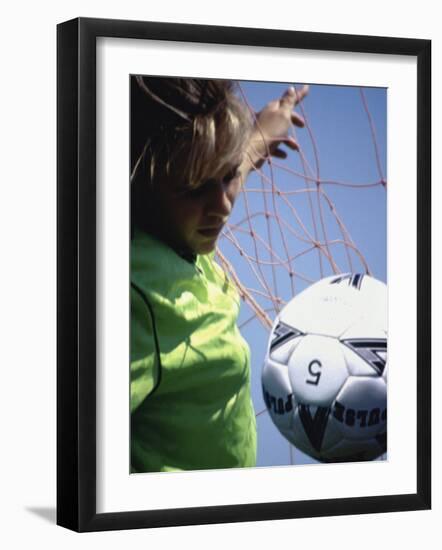 Girl Standing in a Goal Looking at a Soccer Ball-null-Framed Photographic Print