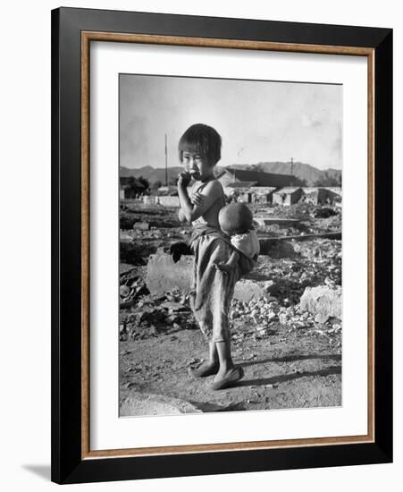 Girl Standing in Rubble from the Korean Civil War, Carrying a Baby in a Sling on Her Back-Joe Scherschel-Framed Photographic Print