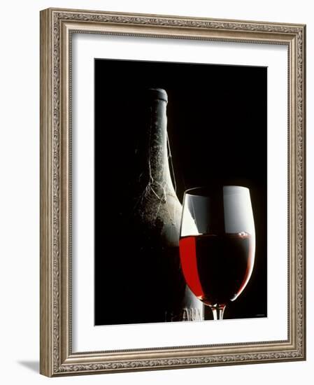 Glass of Red Wine with Aged Bottle, Cobwebs-Bodo A^ Schieren-Framed Photographic Print