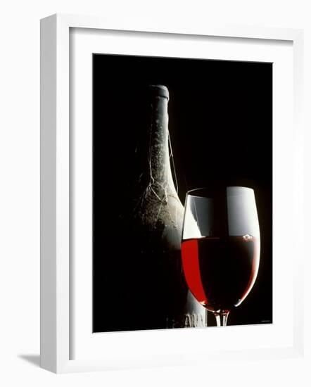 Glass of Red Wine with Aged Bottle, Cobwebs-Bodo A^ Schieren-Framed Photographic Print