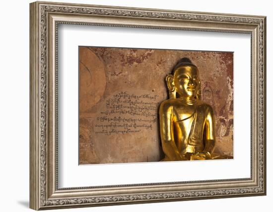 Golden Buddha Statue in Front of Burmese Writing on Wall, Bagan, Myanmar-Harry Marx-Framed Photographic Print