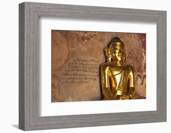 Golden Buddha Statue in Front of Burmese Writing on Wall, Bagan, Myanmar-Harry Marx-Framed Photographic Print