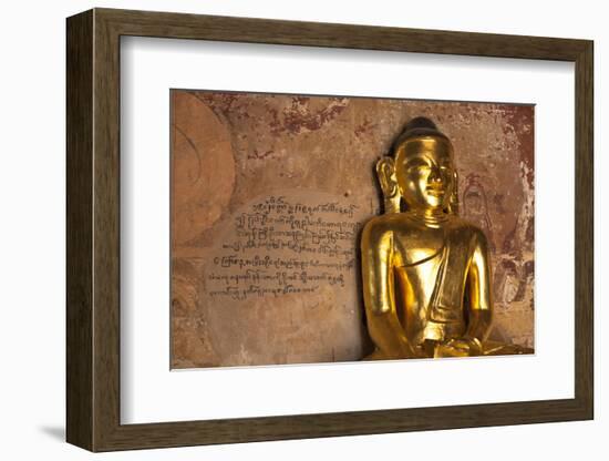 Golden Buddha Statue in Front of Burmese Writing on Wall, Bagan, Myanmar-Harry Marx-Framed Photographic Print