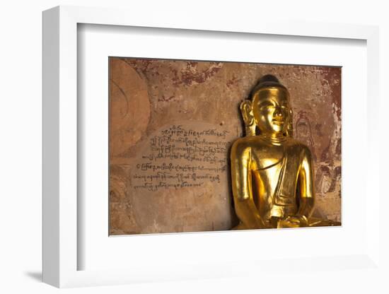 Golden Buddha Statue in Front of Burmese Writing on Wall, Bagan, Myanmar-Harry Marx-Framed Photographic Print