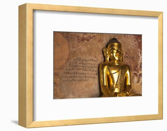 Golden Buddha Statue in Front of Burmese Writing on Wall, Bagan, Myanmar-Harry Marx-Framed Photographic Print