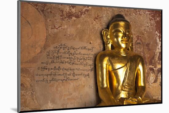 Golden Buddha Statue in Front of Burmese Writing on Wall, Bagan, Myanmar-Harry Marx-Mounted Photographic Print