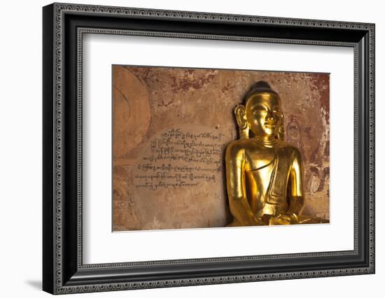 Golden Buddha Statue in Front of Burmese Writing on Wall, Bagan, Myanmar-Harry Marx-Framed Photographic Print