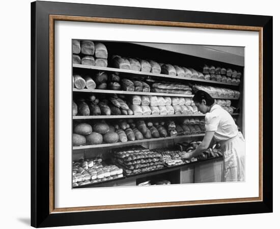 Good of Worker in Bakery Standing in Front of Shelves of Various Kinds of Breads and Rolls-Alfred Eisenstaedt-Framed Photographic Print