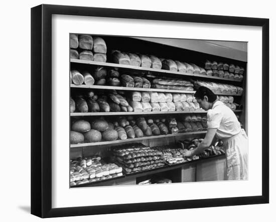 Good of Worker in Bakery Standing in Front of Shelves of Various Kinds of Breads and Rolls-Alfred Eisenstaedt-Framed Photographic Print