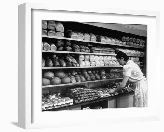 Good of Worker in Bakery Standing in Front of Shelves of Various Kinds of Breads and Rolls-Alfred Eisenstaedt-Framed Photographic Print