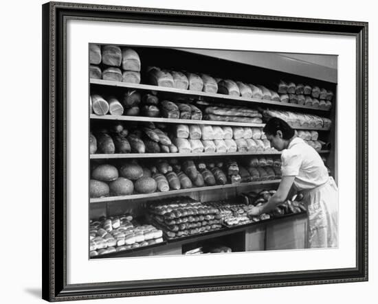 Good of Worker in Bakery Standing in Front of Shelves of Various Kinds of Breads and Rolls-Alfred Eisenstaedt-Framed Photographic Print