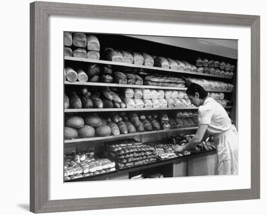 Good of Worker in Bakery Standing in Front of Shelves of Various Kinds of Breads and Rolls-Alfred Eisenstaedt-Framed Photographic Print