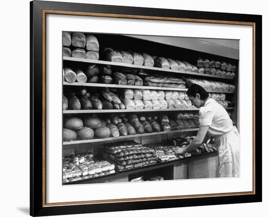 Good of Worker in Bakery Standing in Front of Shelves of Various Kinds of Breads and Rolls-Alfred Eisenstaedt-Framed Photographic Print