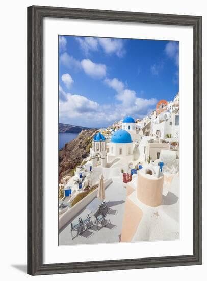 Greek Church with Three Blue Domes in the Village of Oia-Neale Clark-Framed Photographic Print