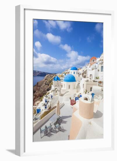 Greek Church with Three Blue Domes in the Village of Oia-Neale Clark-Framed Photographic Print