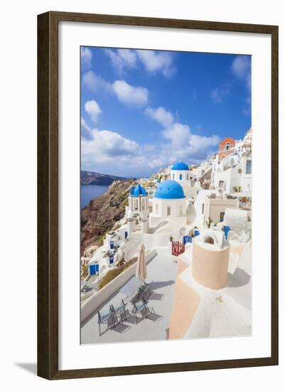 Greek Church with Three Blue Domes in the Village of Oia-Neale Clark-Framed Photographic Print