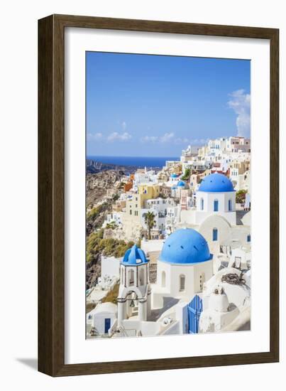 Greek Church with Three Blue Domes in the Village of Oia-Neale Clark-Framed Photographic Print