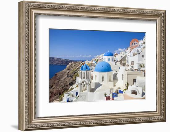 Greek Church with Three Blue Domes in the Village of Oia-Neale Clark-Framed Photographic Print