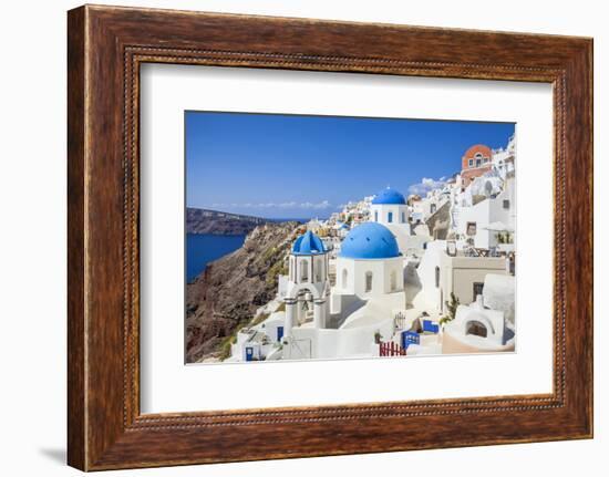 Greek Church with Three Blue Domes in the Village of Oia-Neale Clark-Framed Photographic Print