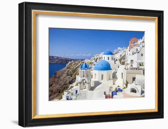 Greek Church with Three Blue Domes in the Village of Oia-Neale Clark-Framed Photographic Print