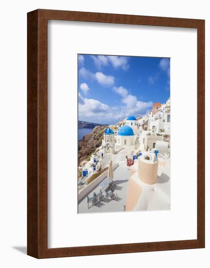 Greek Church with Three Blue Domes in the Village of Oia-Neale Clark-Framed Photographic Print