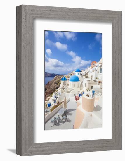 Greek Church with Three Blue Domes in the Village of Oia-Neale Clark-Framed Photographic Print