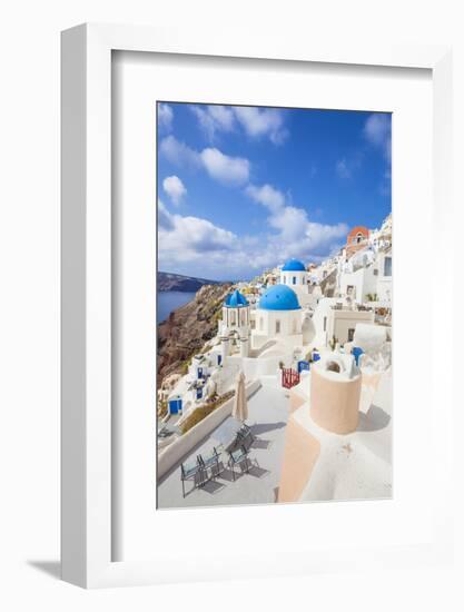Greek Church with Three Blue Domes in the Village of Oia-Neale Clark-Framed Photographic Print