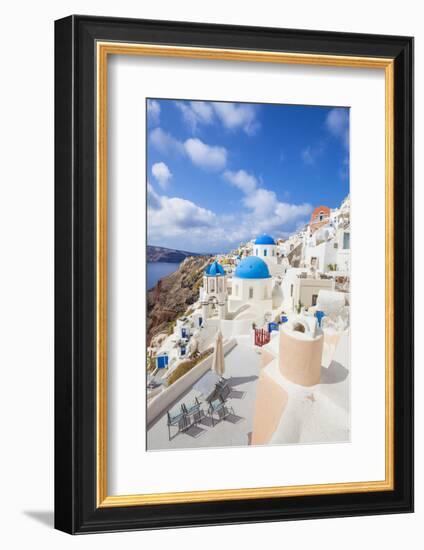 Greek Church with Three Blue Domes in the Village of Oia-Neale Clark-Framed Photographic Print