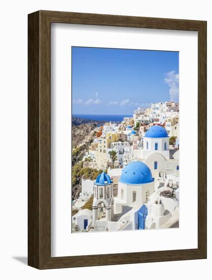 Greek Church with Three Blue Domes in the Village of Oia-Neale Clark-Framed Photographic Print