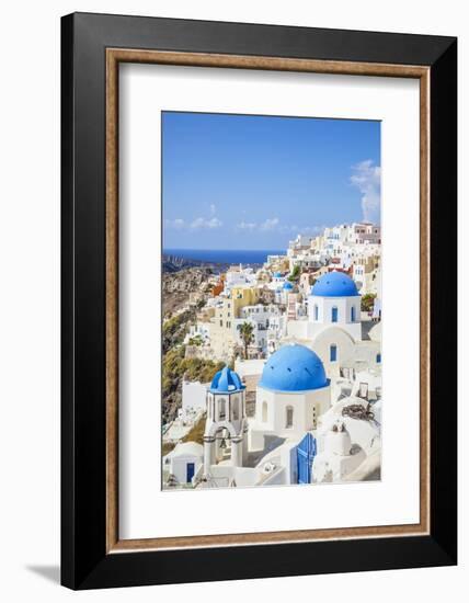 Greek Church with Three Blue Domes in the Village of Oia-Neale Clark-Framed Photographic Print