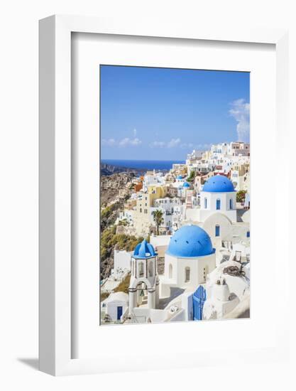 Greek Church with Three Blue Domes in the Village of Oia-Neale Clark-Framed Photographic Print