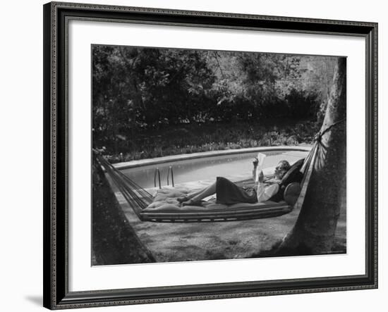 Greer Garson Reading While Relaxing in a Hammock Near Her Pool at Home-Peter Stackpole-Framed Premium Photographic Print