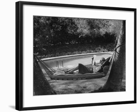 Greer Garson Reading While Relaxing in a Hammock Near Her Pool at Home-Peter Stackpole-Framed Premium Photographic Print