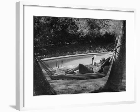 Greer Garson Reading While Relaxing in a Hammock Near Her Pool at Home-Peter Stackpole-Framed Premium Photographic Print