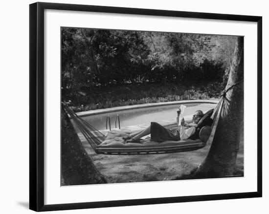 Greer Garson Reading While Relaxing in a Hammock Near Her Pool at Home-Peter Stackpole-Framed Premium Photographic Print