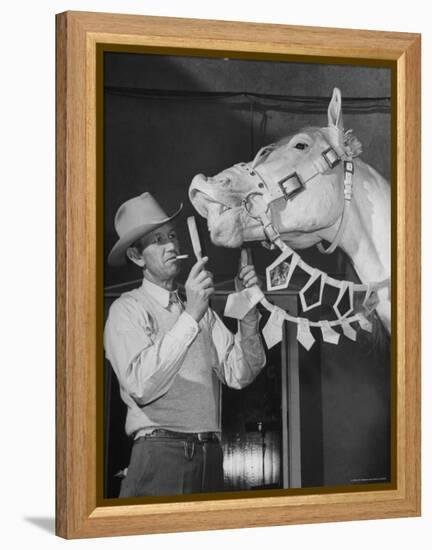 Groom Cleaning Horse's Teeth During Filming of the Movie "The Ziegfeld Follies"-John Florea-Framed Premier Image Canvas