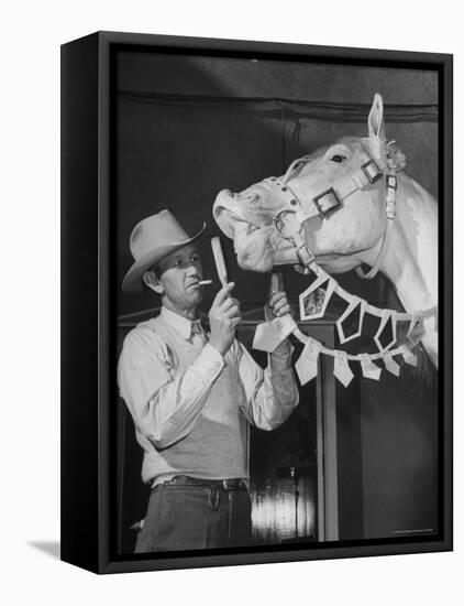 Groom Cleaning Horse's Teeth During Filming of the Movie "The Ziegfeld Follies"-John Florea-Framed Premier Image Canvas