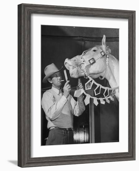 Groom Cleaning Horse's Teeth During Filming of the Movie "The Ziegfeld Follies"-John Florea-Framed Photographic Print