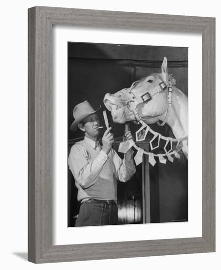 Groom Cleaning Horse's Teeth During Filming of the Movie "The Ziegfeld Follies"-John Florea-Framed Photographic Print