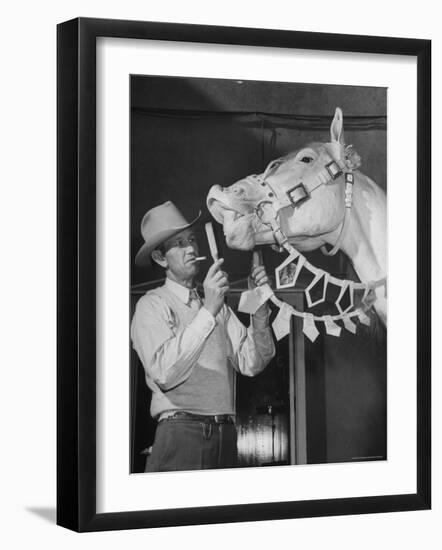 Groom Cleaning Horse's Teeth During Filming of the Movie "The Ziegfeld Follies"-John Florea-Framed Photographic Print
