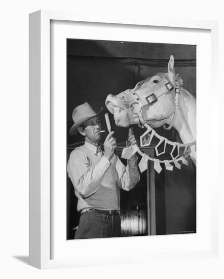 Groom Cleaning Horse's Teeth During Filming of the Movie "The Ziegfeld Follies"-John Florea-Framed Photographic Print