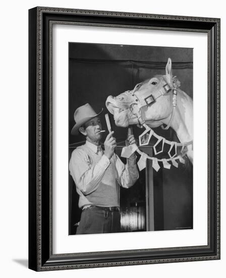 Groom Cleaning Horse's Teeth During Filming of the Movie "The Ziegfeld Follies"-John Florea-Framed Photographic Print